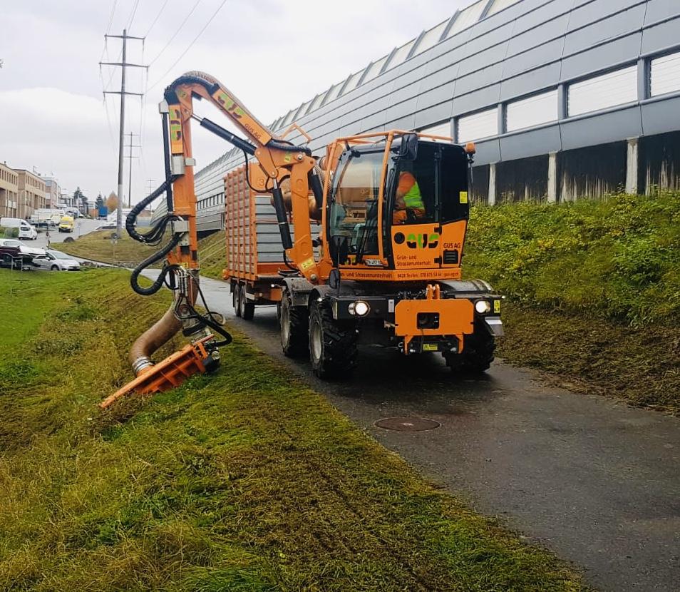 Energreen mit Messerbalkenabsaugung auf Gehweg in städtischer Umgebung.